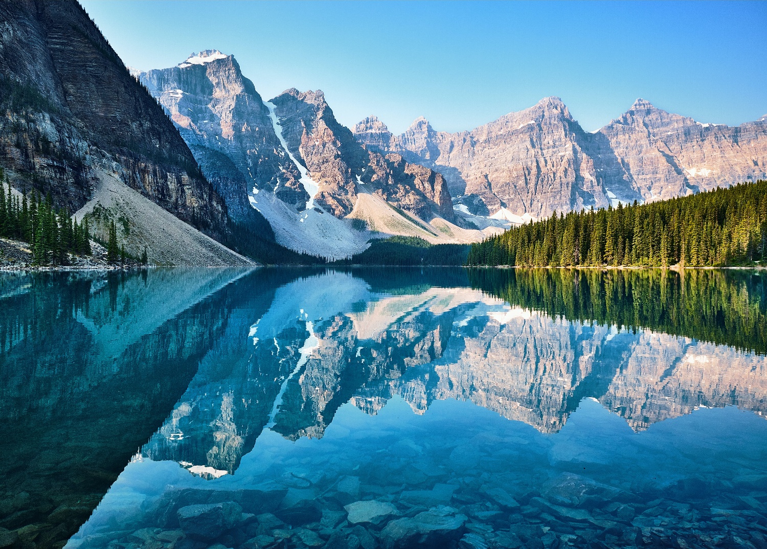 Snow covered mountains reflected in glacial lake